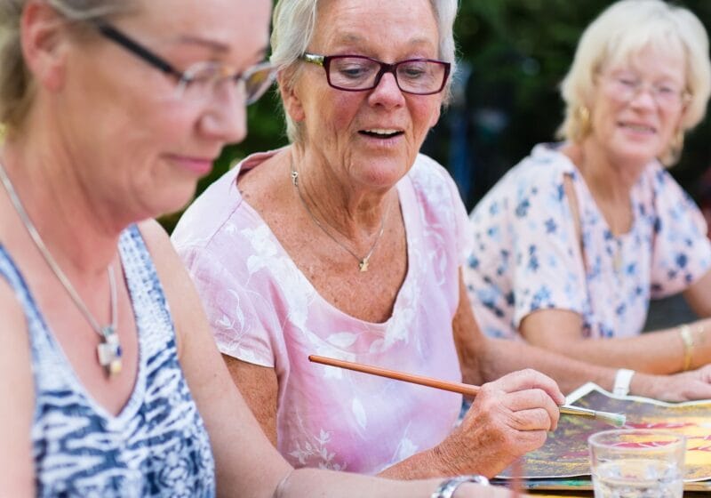 older women painting and socializing outdoors