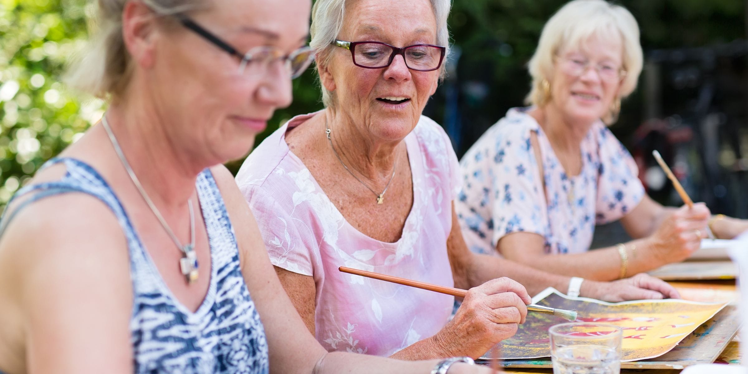 older women painting and socializing outdoors
