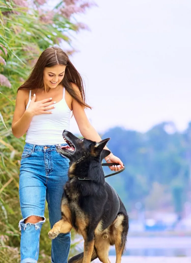 woman walking her german Shepard dog outside in park for self-care