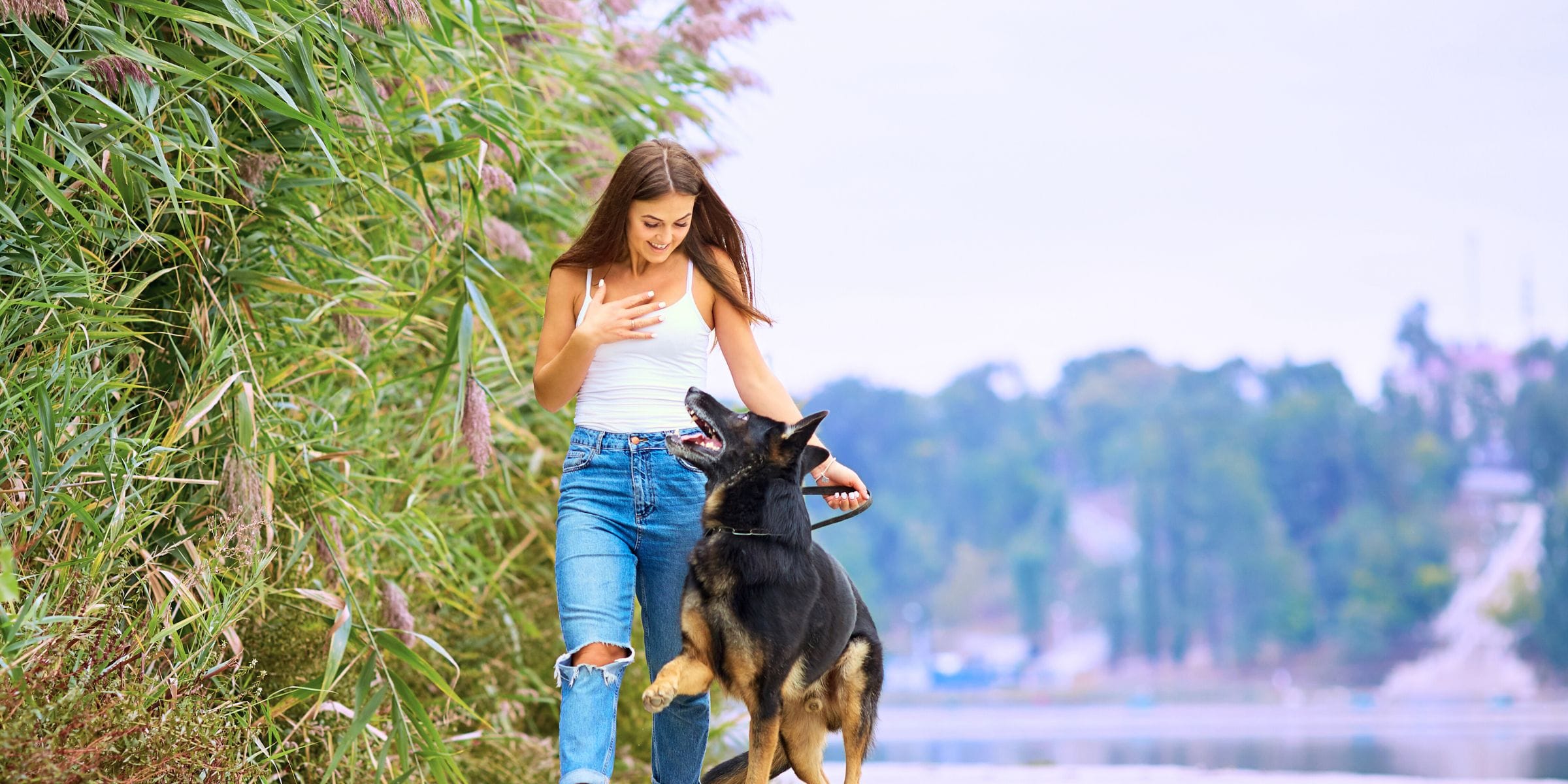 woman walking her german Shepard dog outside in park for self-care