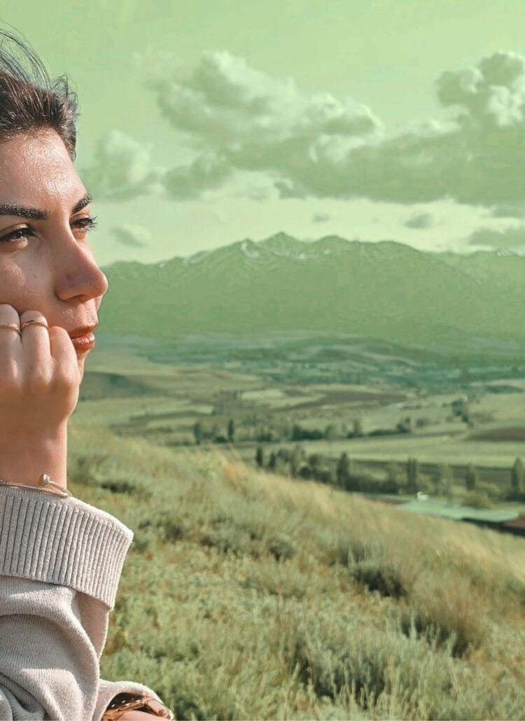 woman looking over the mountain view adjusting to her new way of life on a farm