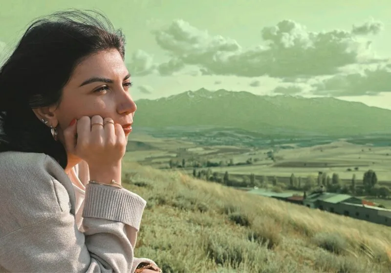 woman looking over the mountain view adjusting to her new way of life on a farm