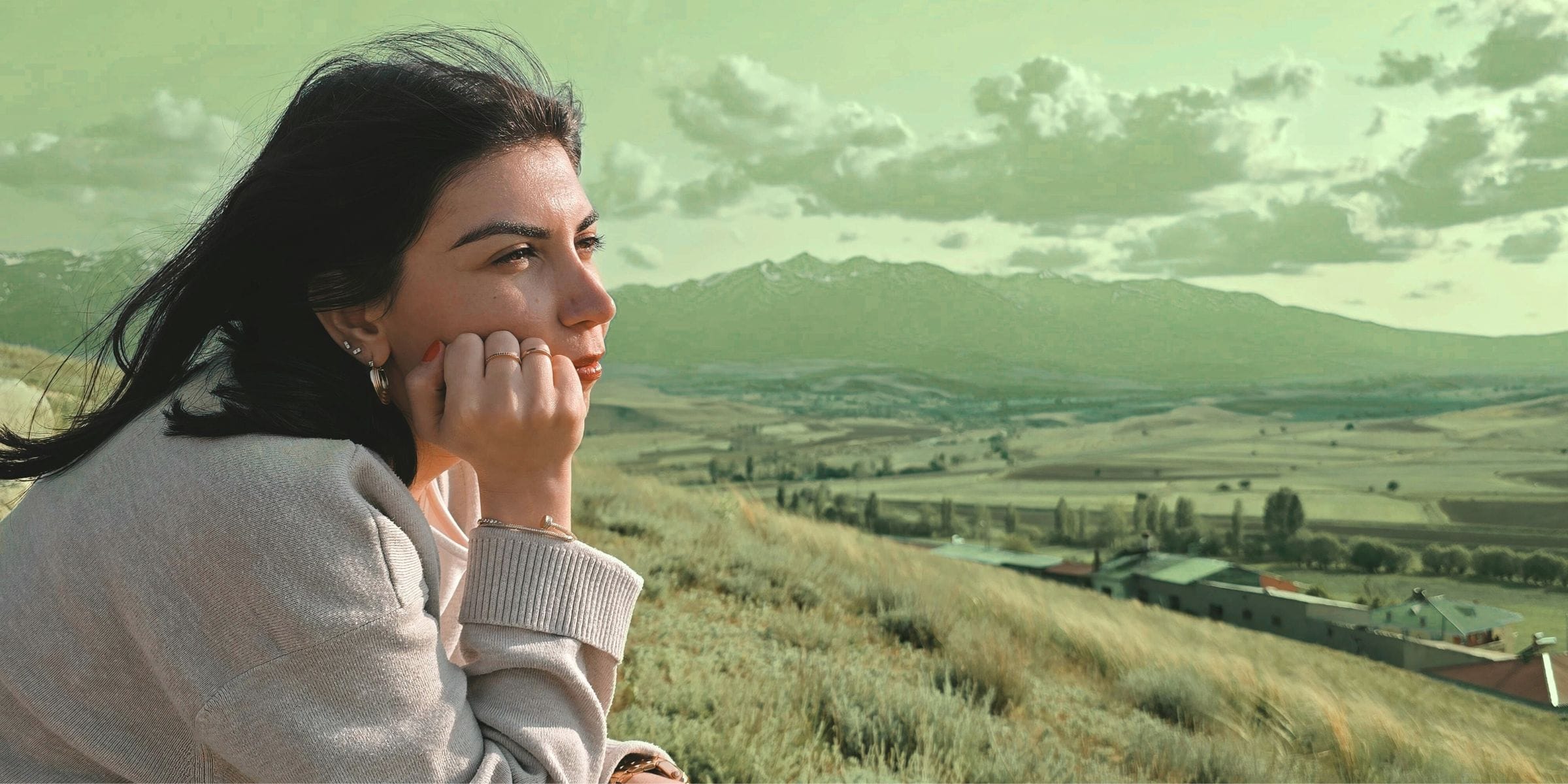 woman looking over the mountain view adjusting to her new way of life on a farm