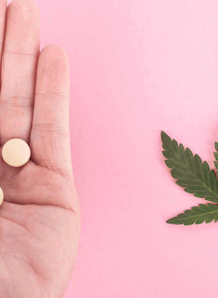 hand holding pills next to cannabis leaf unsafe drug interaction