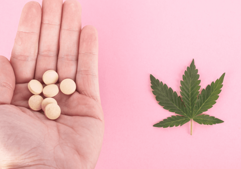 hand holding pills next to cannabis leaf unsafe drug interaction