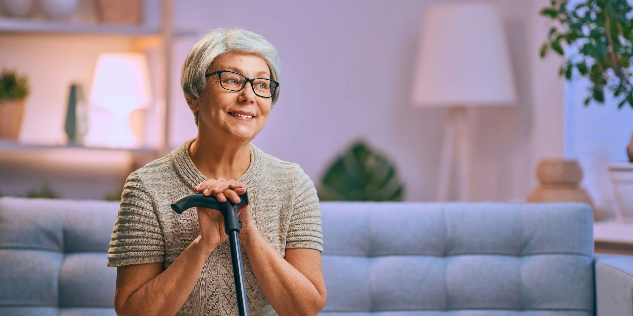senior woman with arthritis pain resting with cane on couch
