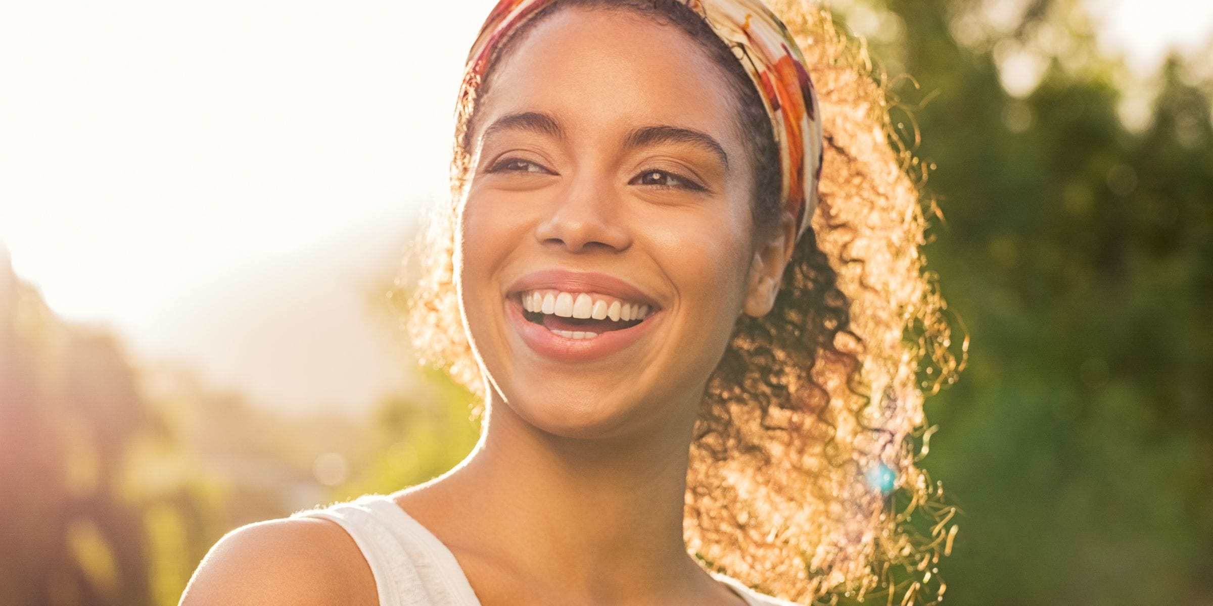 smiling black woman with perfectly straight teeth standing outside