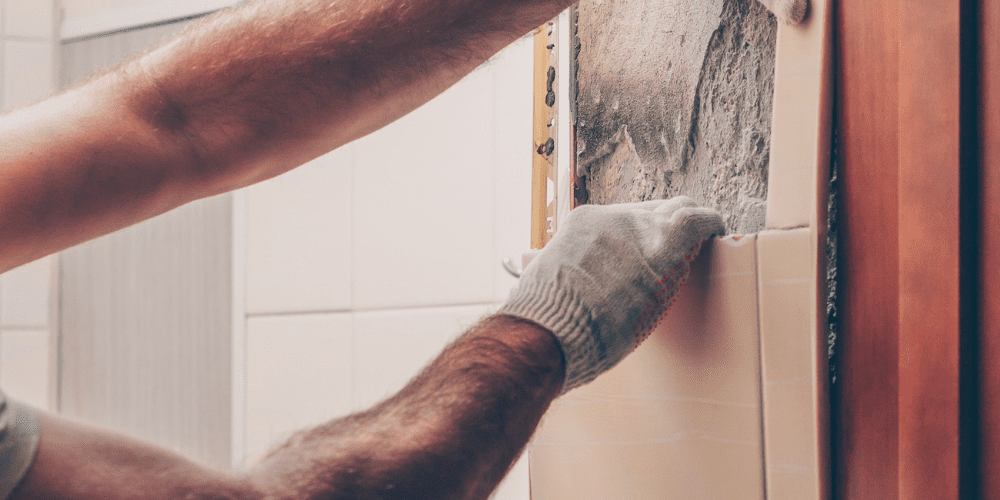 handyman uncovering absestos in house wall