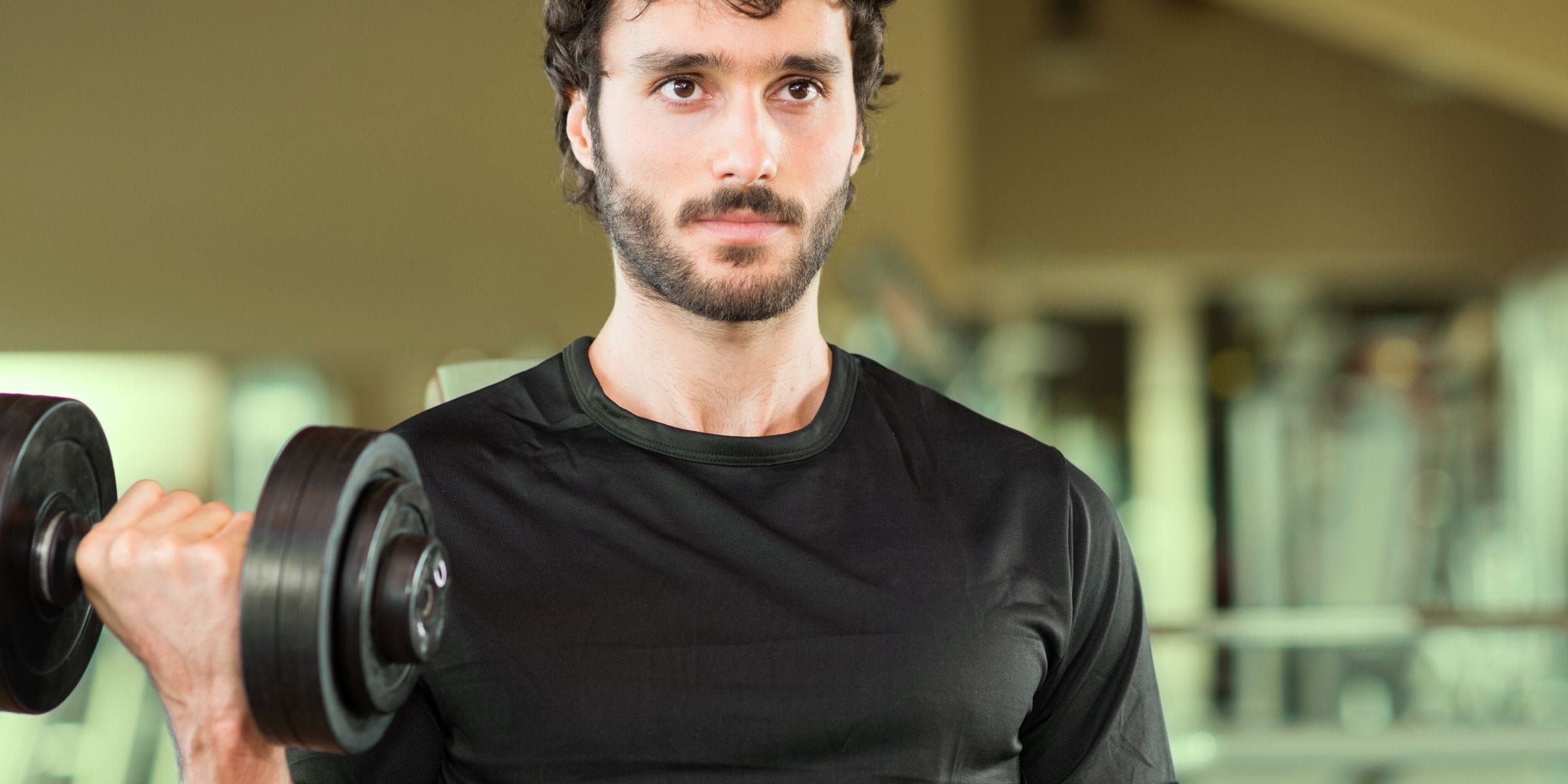 man lifting weights in the gym thinking about muscle recovery