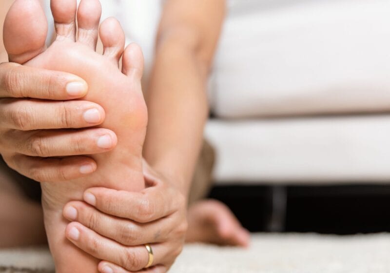 woman holding foot with peripheral neuropathy pain symptoms