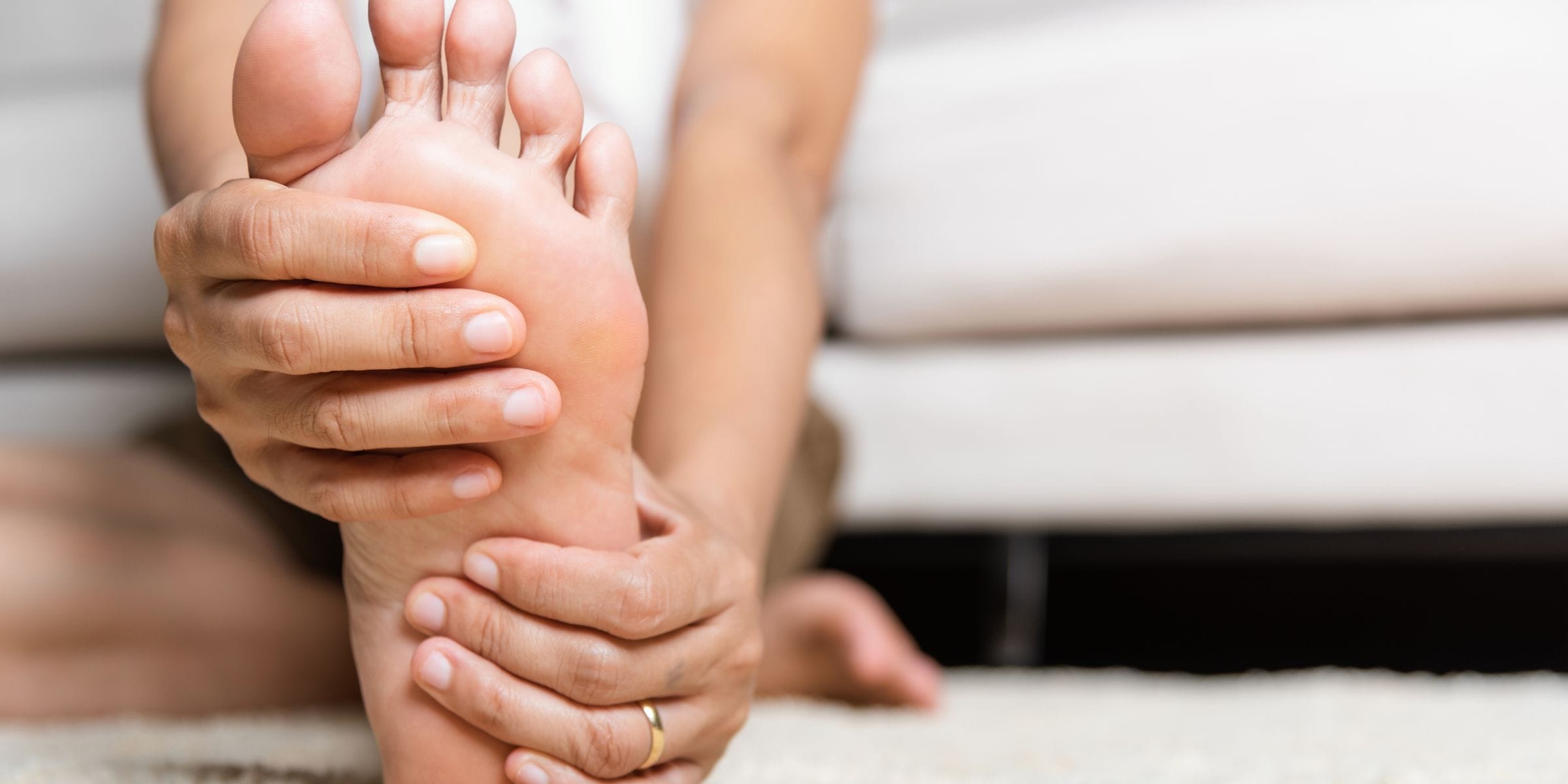 woman holding foot with peripheral neuropathy pain symptoms