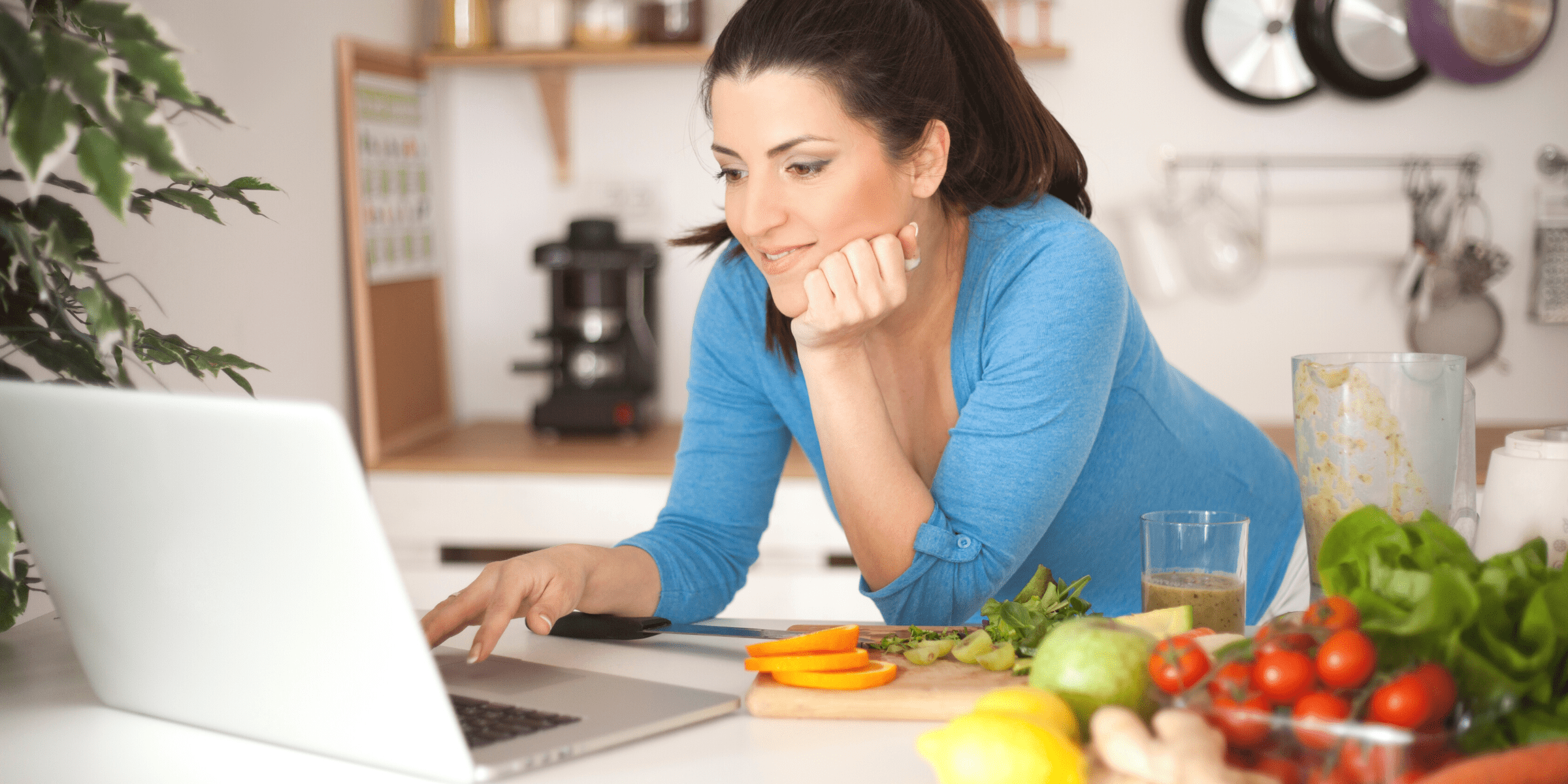 young mom picking out healthy foods on laptop in kitchen