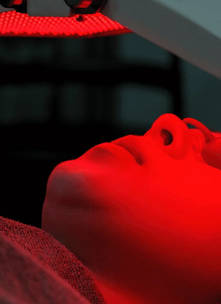 woman doing anti-aging red light therapy for wrinkles on her face