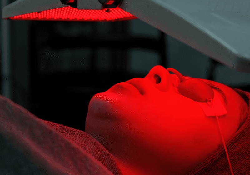 woman doing anti-aging red light therapy for wrinkles on her face