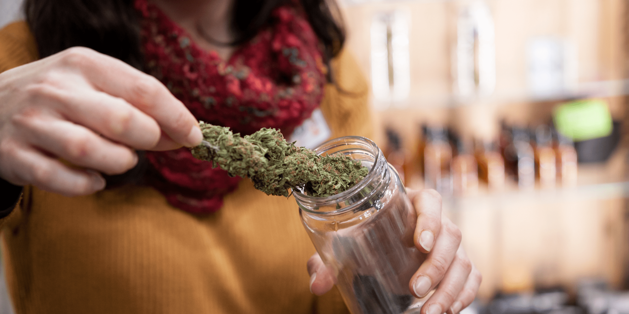 woman putting marijuana in storage container