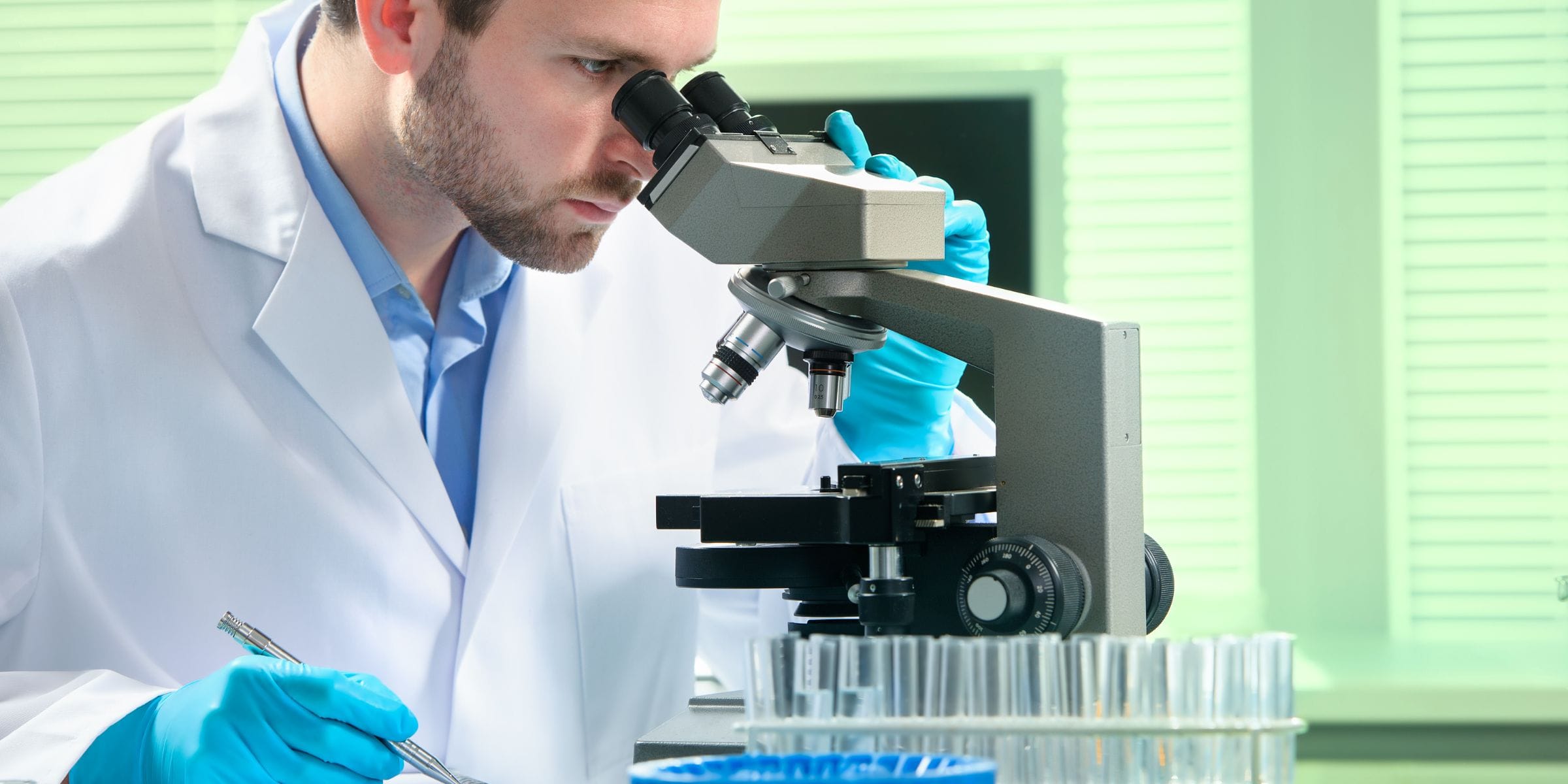 Pathologist diagnosing disease by looking through the microscope in the lab