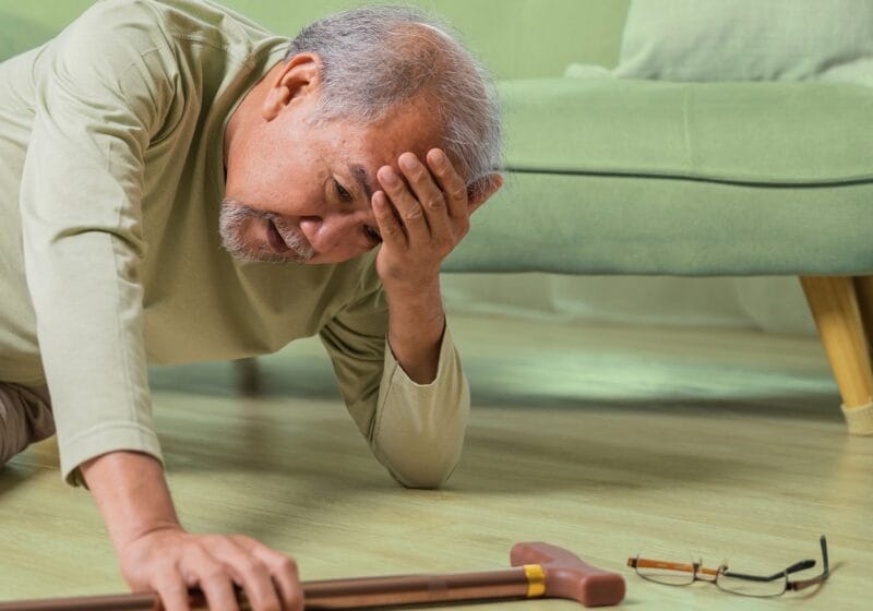 senior man fell on the living room floor with his cane