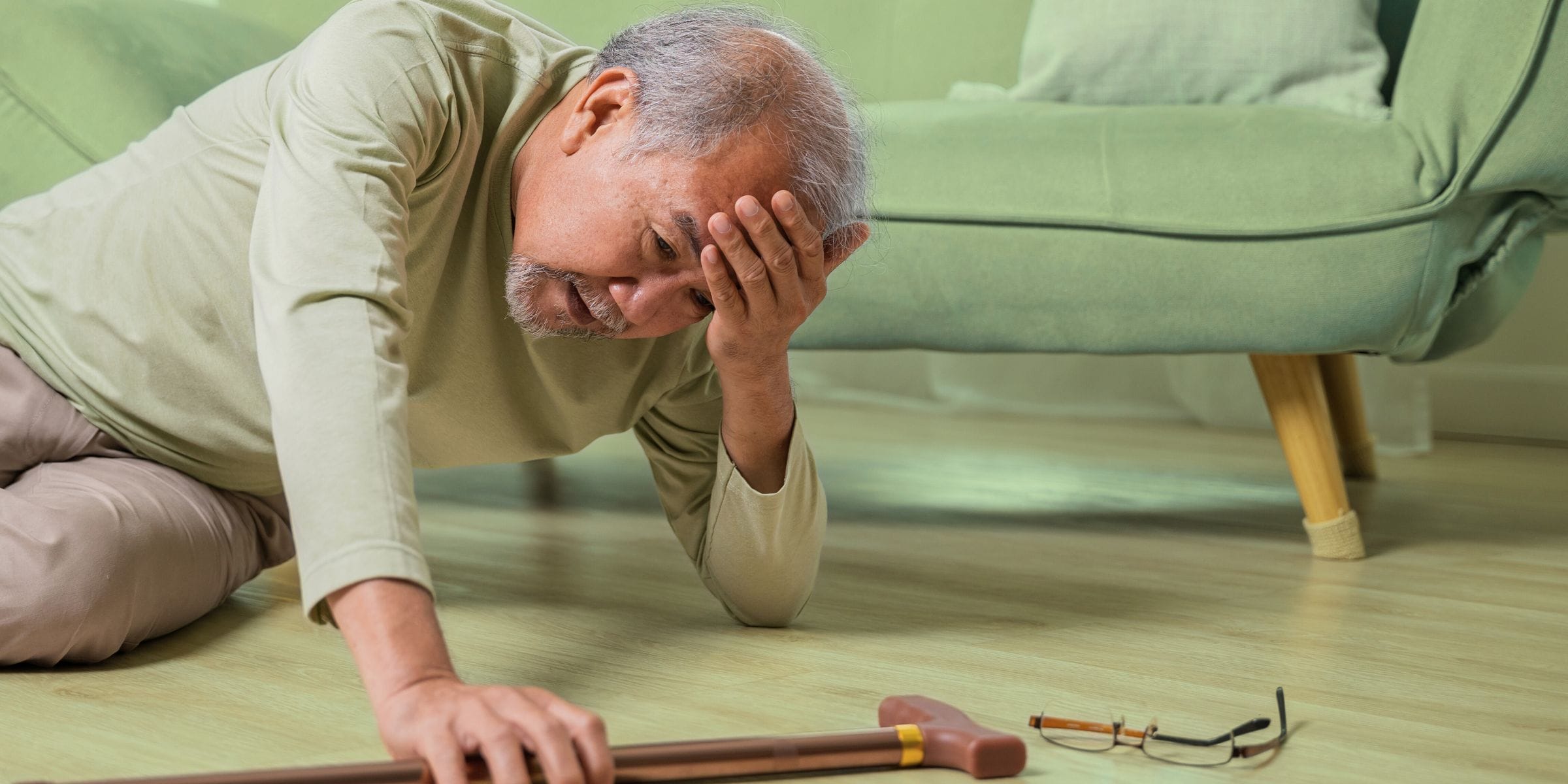 senior man fell on the living room floor with his cane