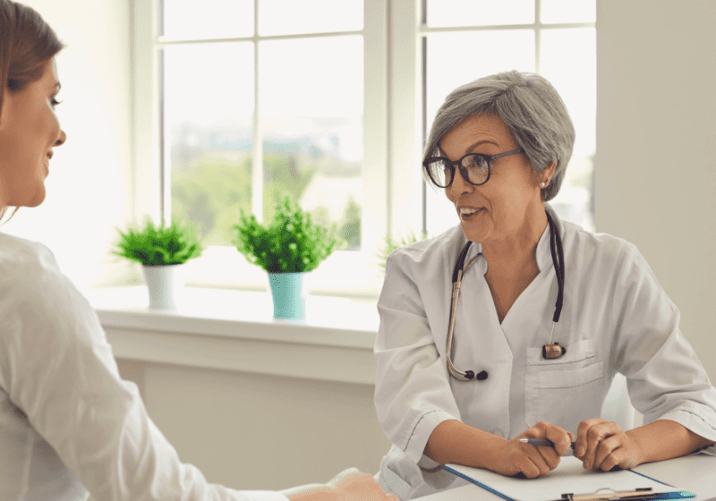 Older female doctor with gray hair talking to woman about medication using in heroin detox