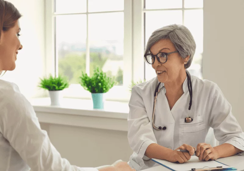 Older female doctor with gray hair talking to woman about medication using in heroin detox