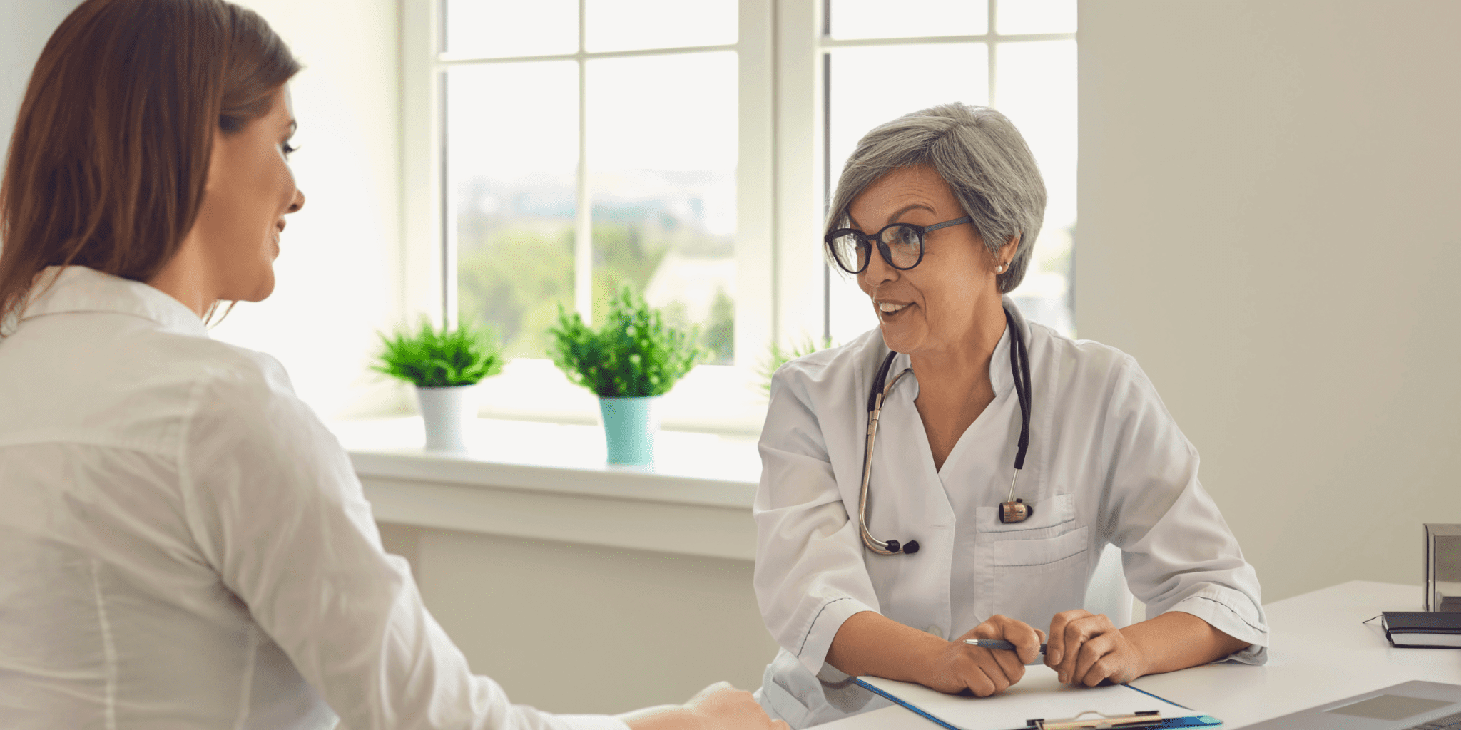 Older female doctor with gray hair talking to woman about medication using in heroin detox