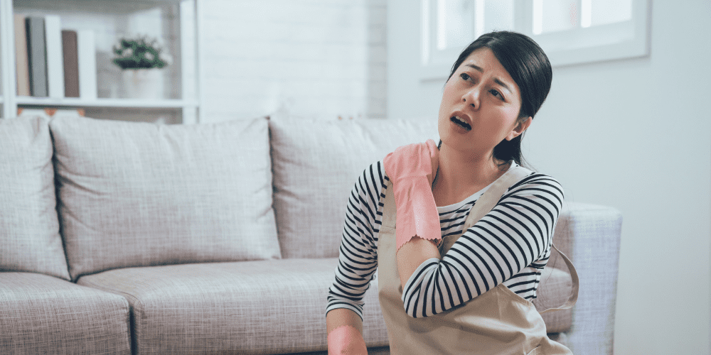 young asian woman cleaning house hurt frozen shoulder