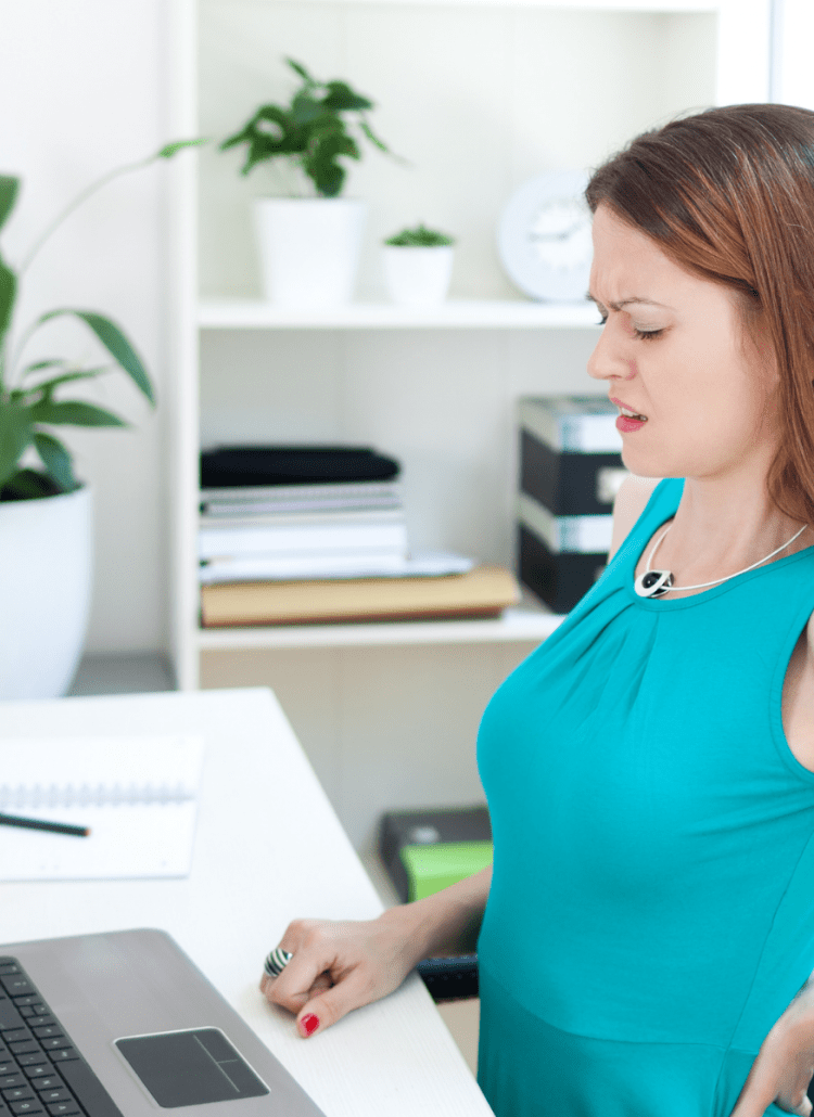 woman with pinched nerves in back sitting in office chair