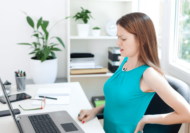 woman with pinched nerves in back sitting in office chair