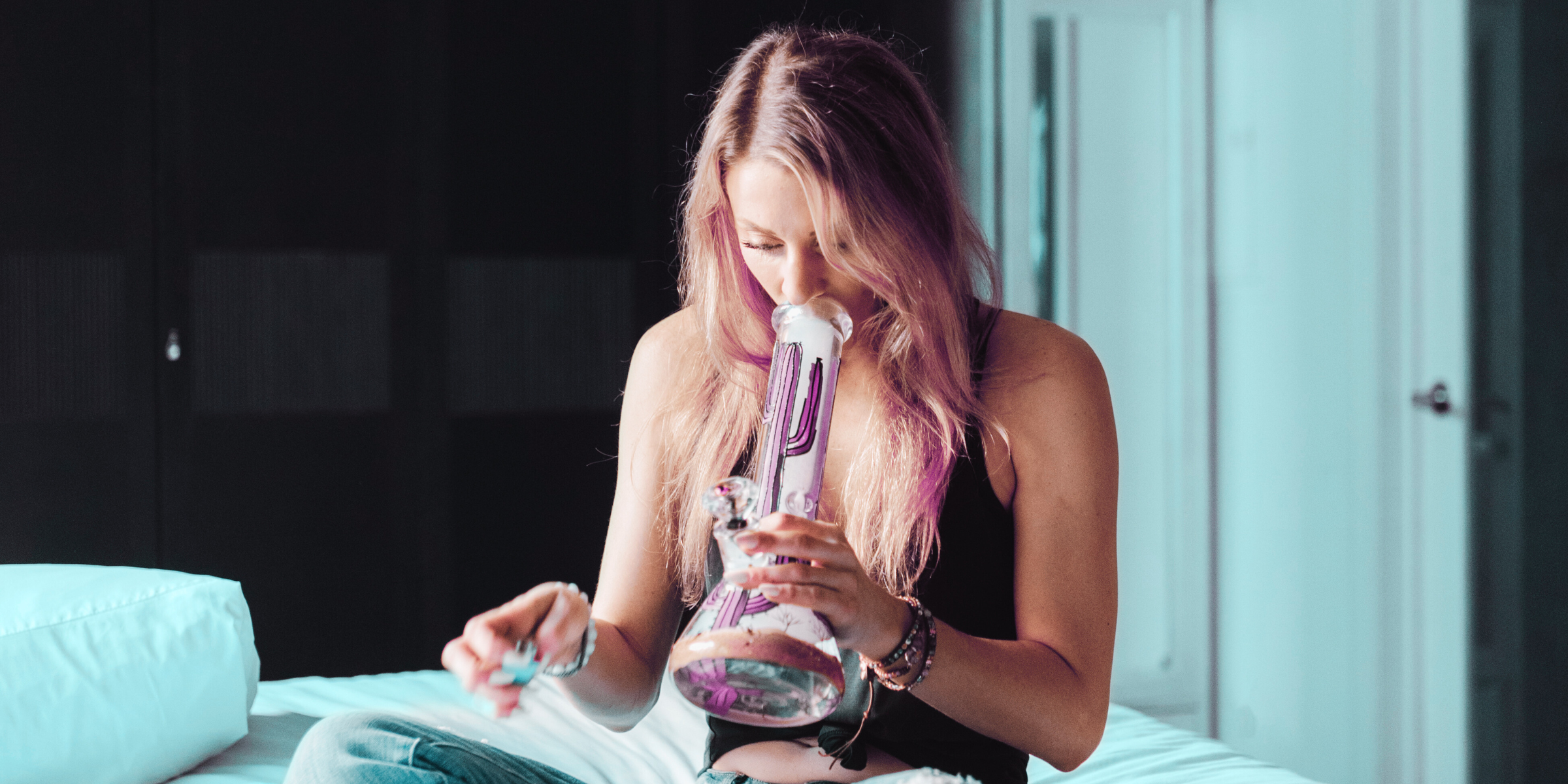 woman smoking cannabis in her bedroom out of glass cactus bong