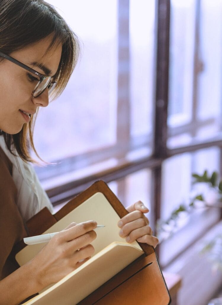 woman writing in her journal and reinforcing healthy habits