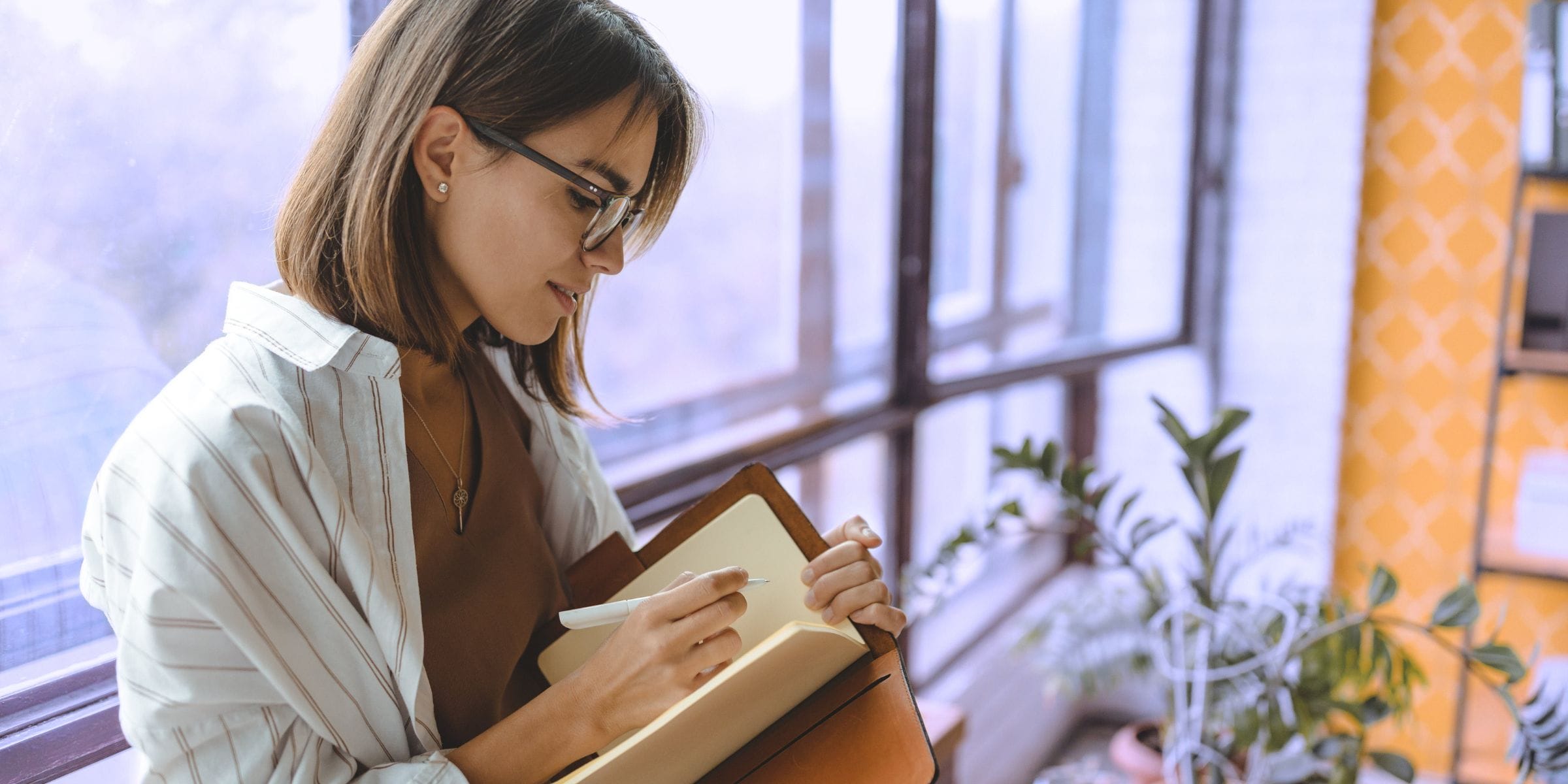 woman writing in her journal and reinforcing healthy habits