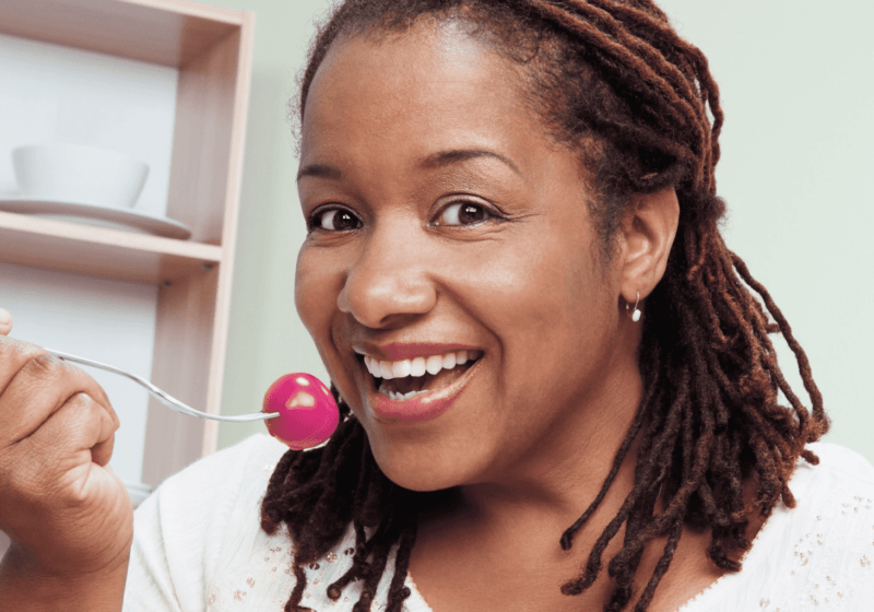 middle-aged black woman with diabetes eating healthy food tomato salad in kitchen