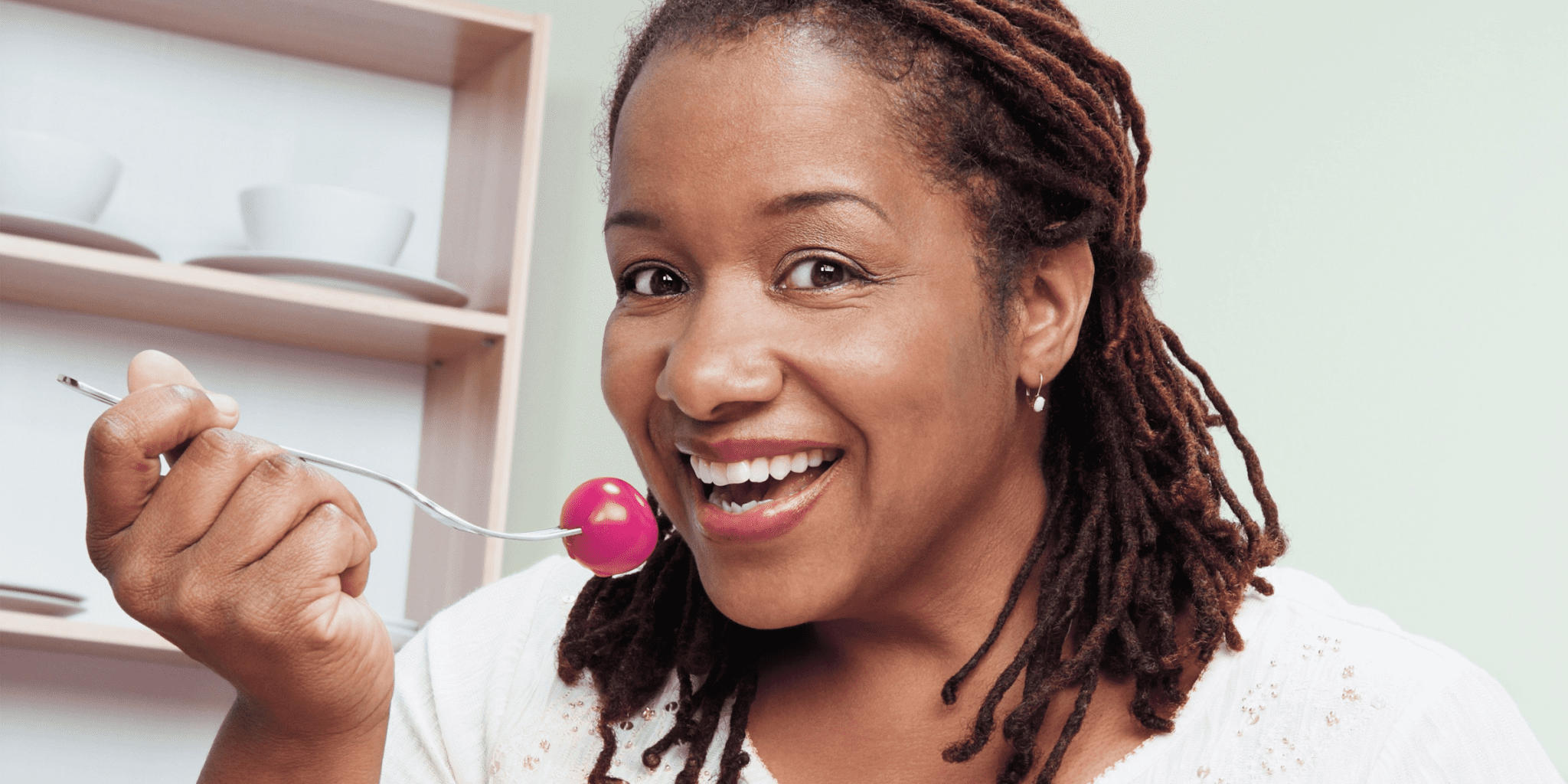 middle-aged black woman with diabetes eating healthy food tomato salad in kitchen