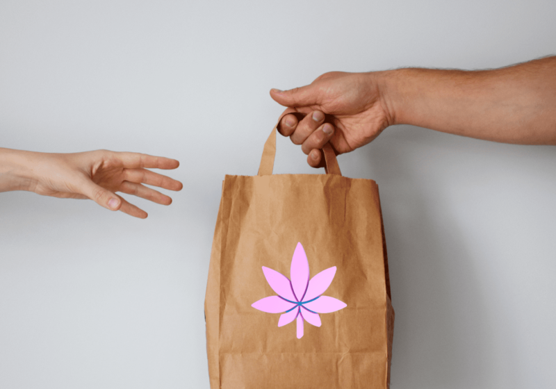 woman receiving weed delivery from man in pink cannabis flower paper bag