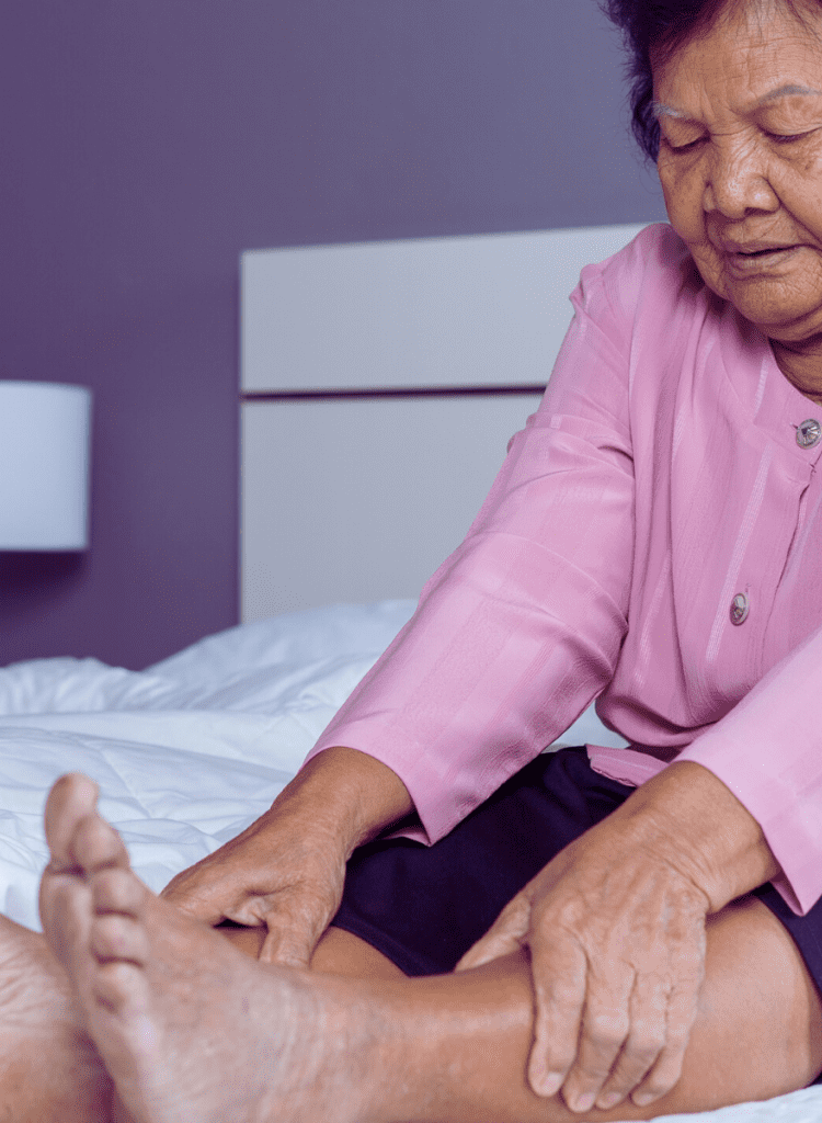 old asian woman in pink shirt in pain from venous insufficiency