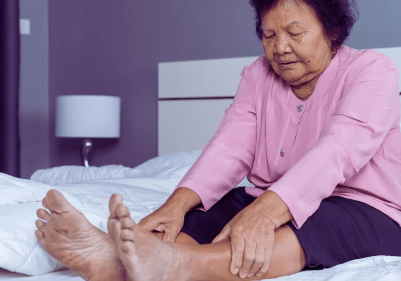 old asian woman in pink shirt in pain from venous insufficiency
