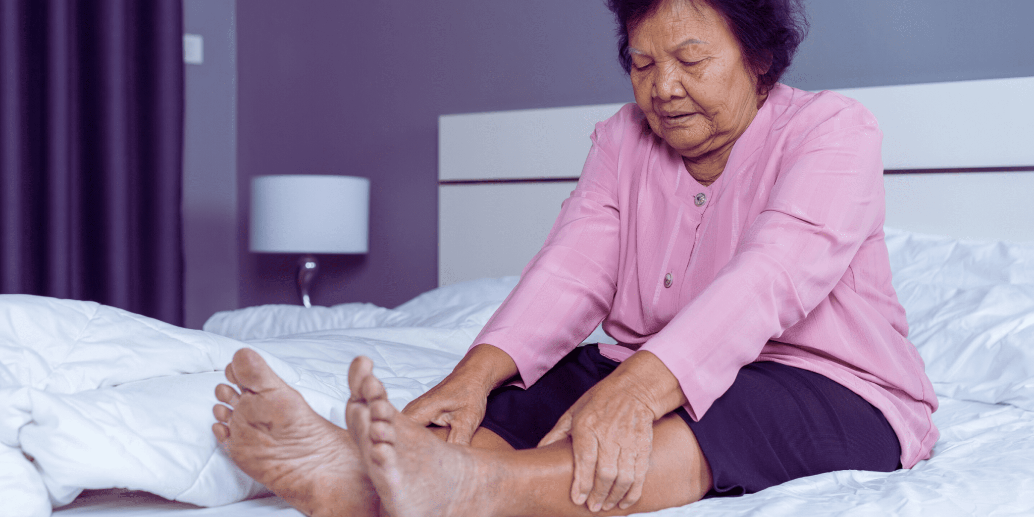 old asian woman in pink shirt in pain from venous insufficiency