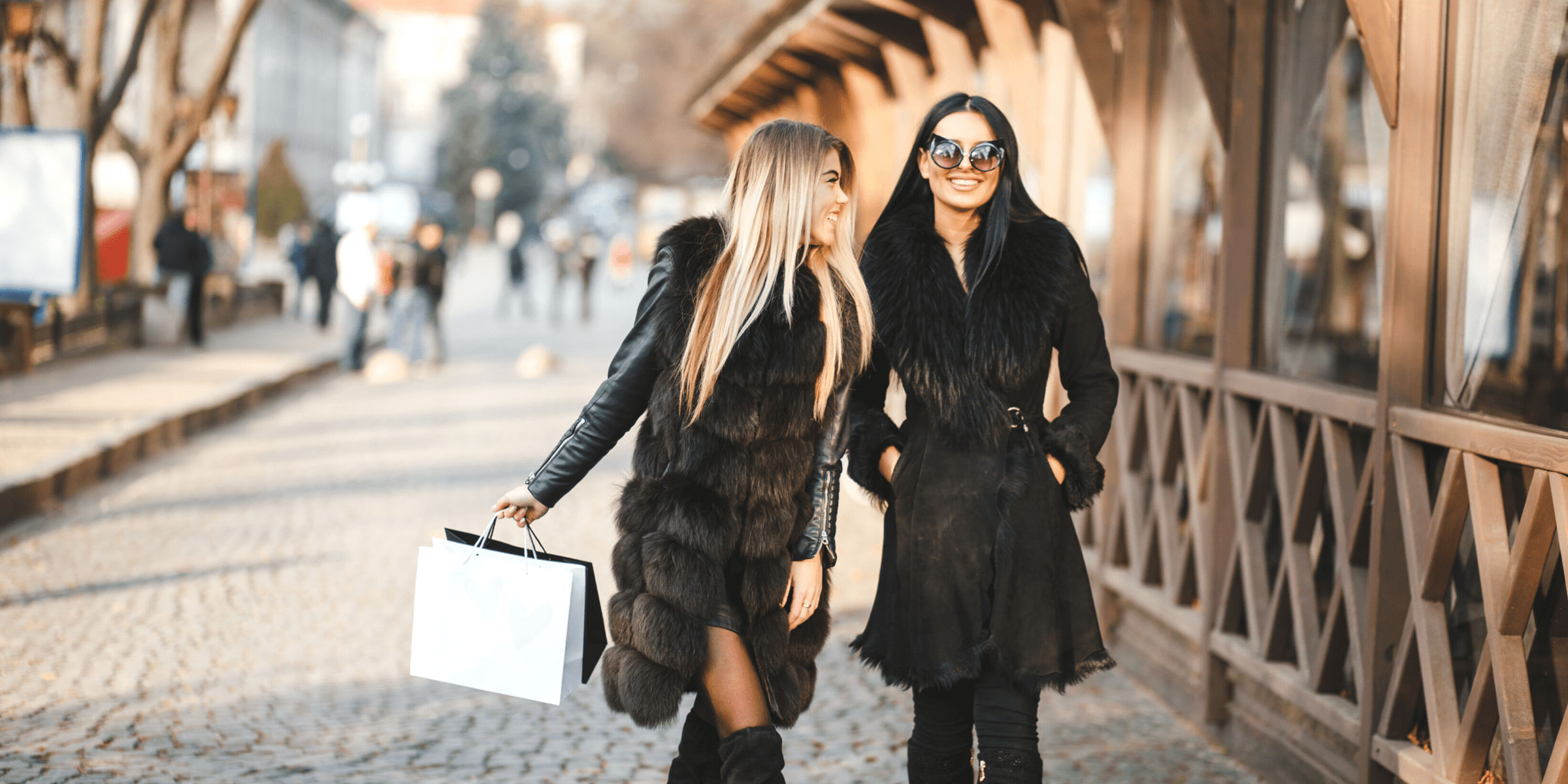 young women black furry coats in spain shopping