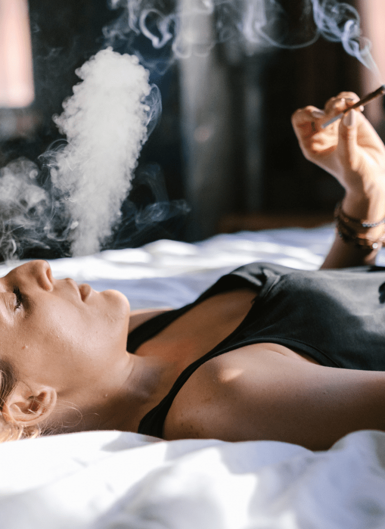 woman smoking cannabis for anxiety on bed