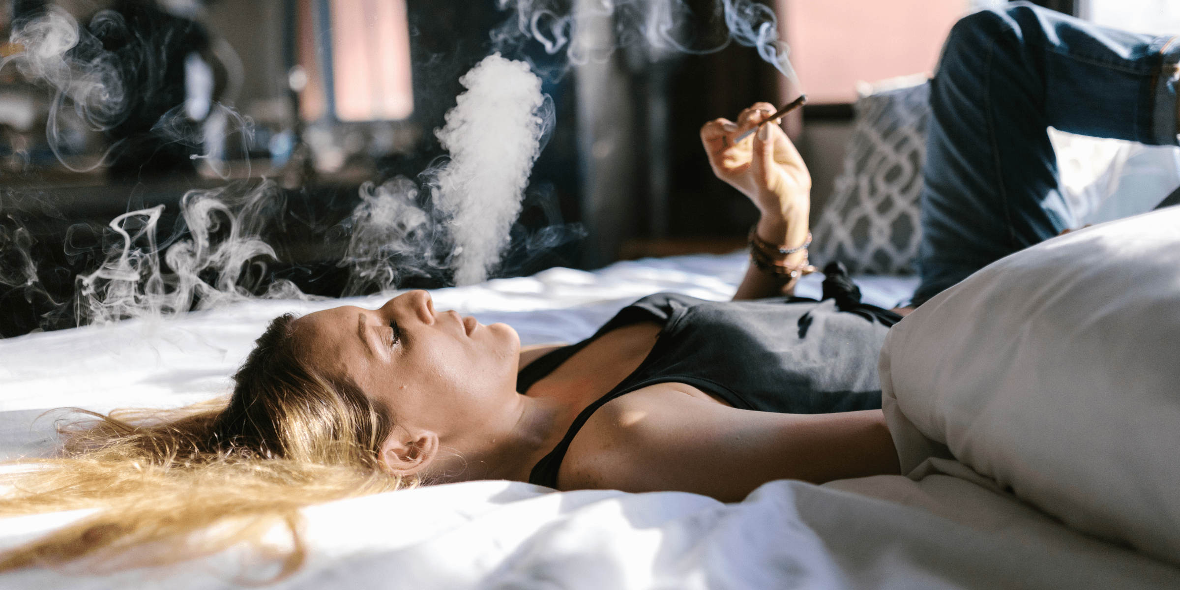 woman smoking cannabis for anxiety on bed