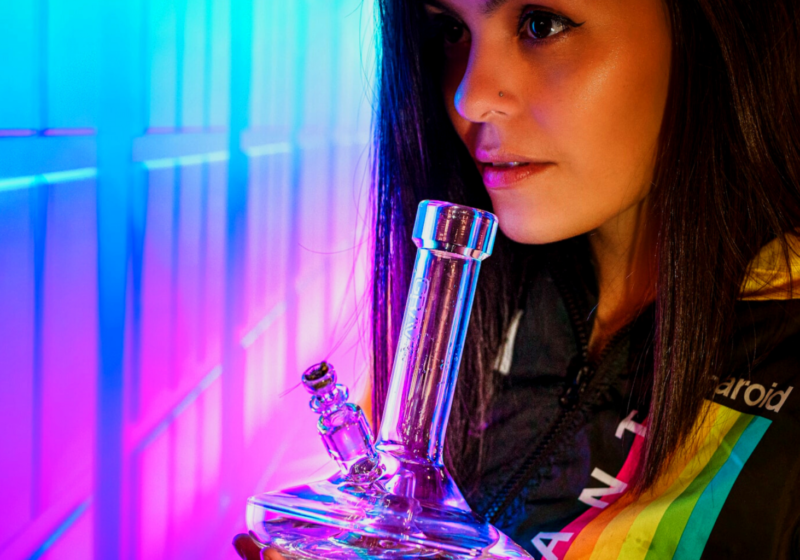 Young woman smoking marijuana out of glass bong