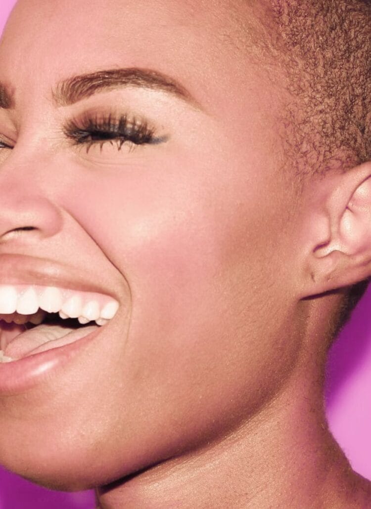 beautiful black woman smiling against pink background perfect oral health