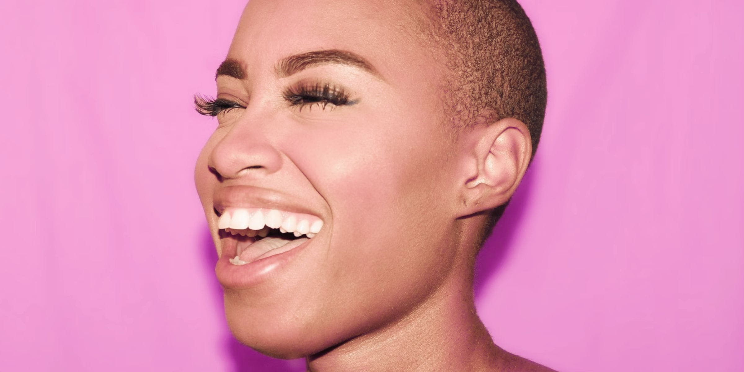 beautiful black woman smiling against pink background perfect oral health