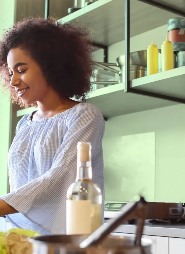 Woman making a healthy salad full of fiber for gut health in her kitchen