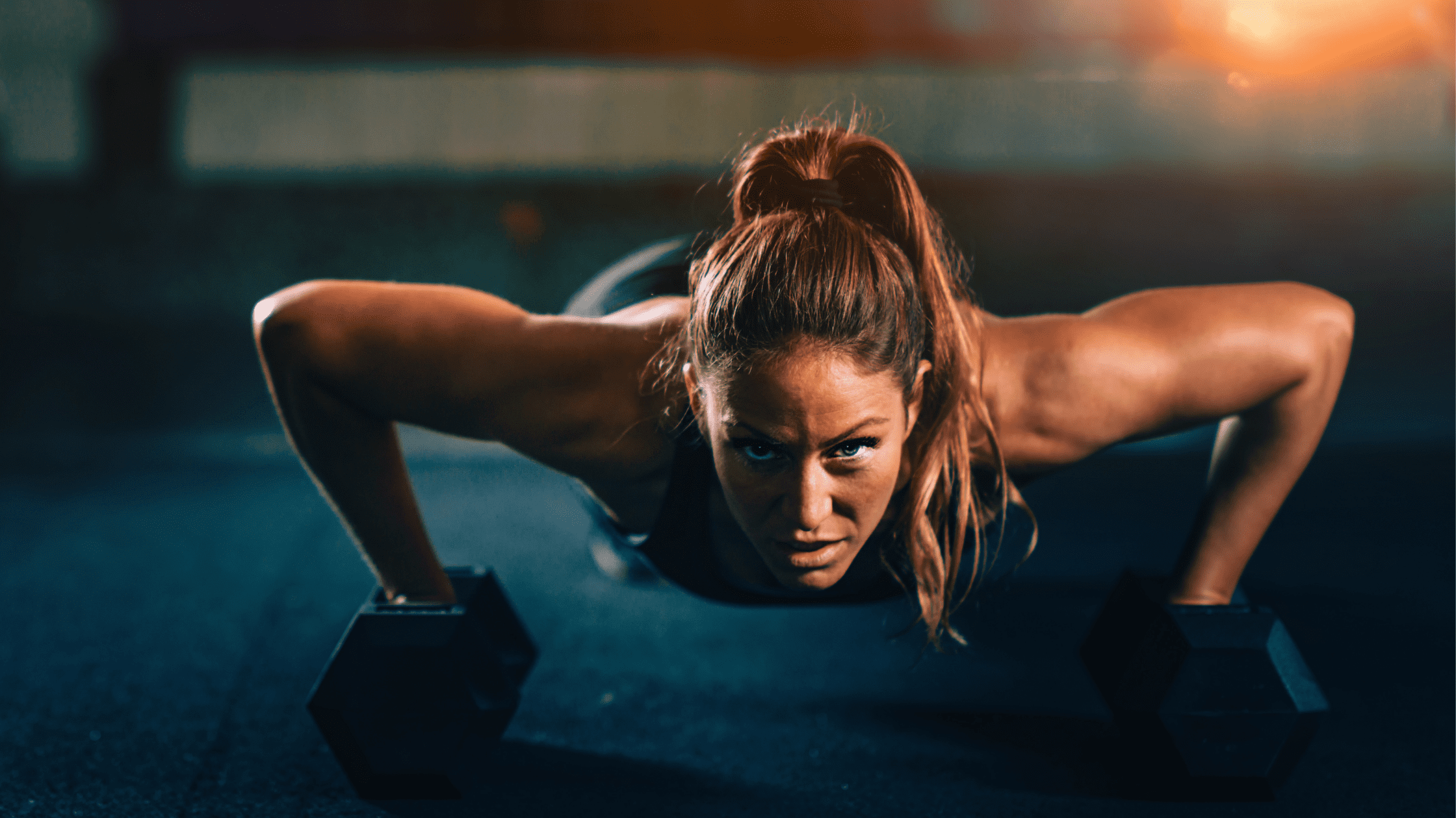 young woman doing pushups on weights after smoking cannabis