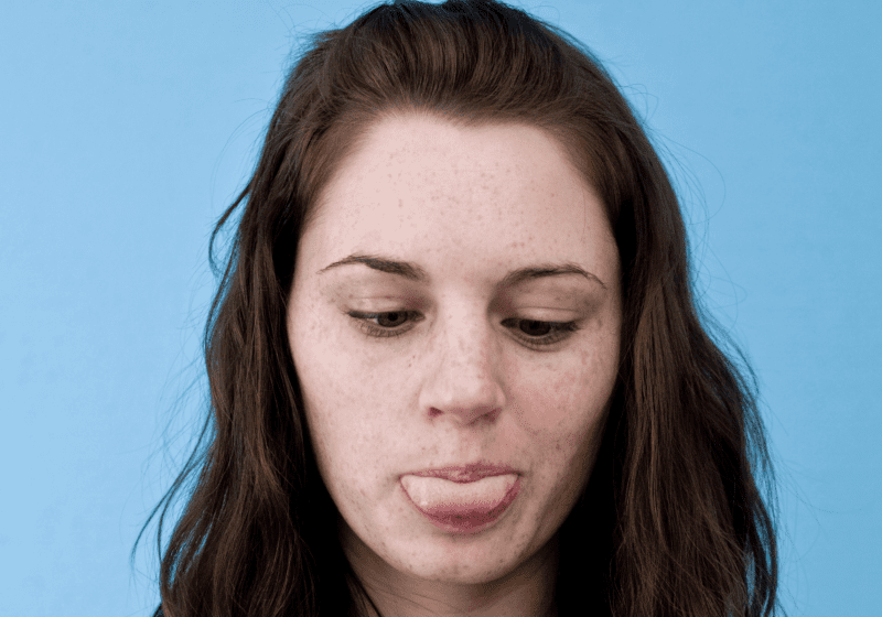 woman sticking out her tongue for cannabis sublingual strip