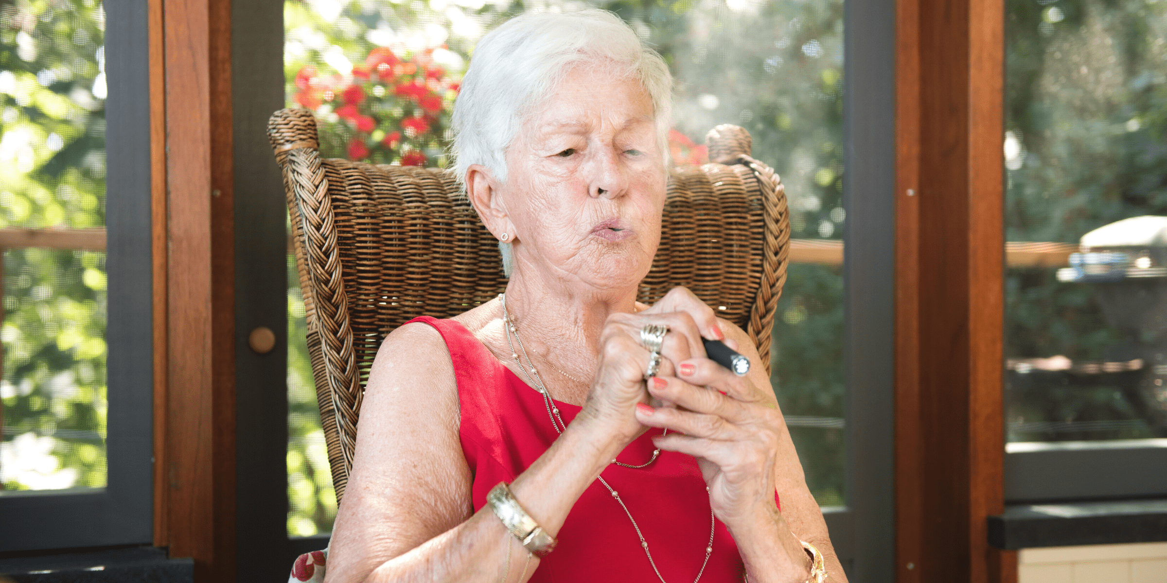senior woman red dress smoking cannabis vape pen for glaucoma