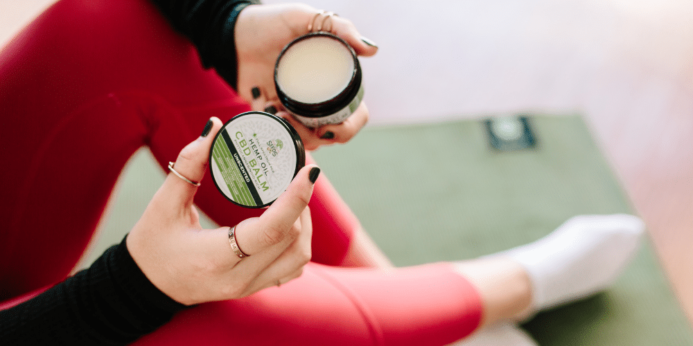 woman applying cbd oil salve after workout