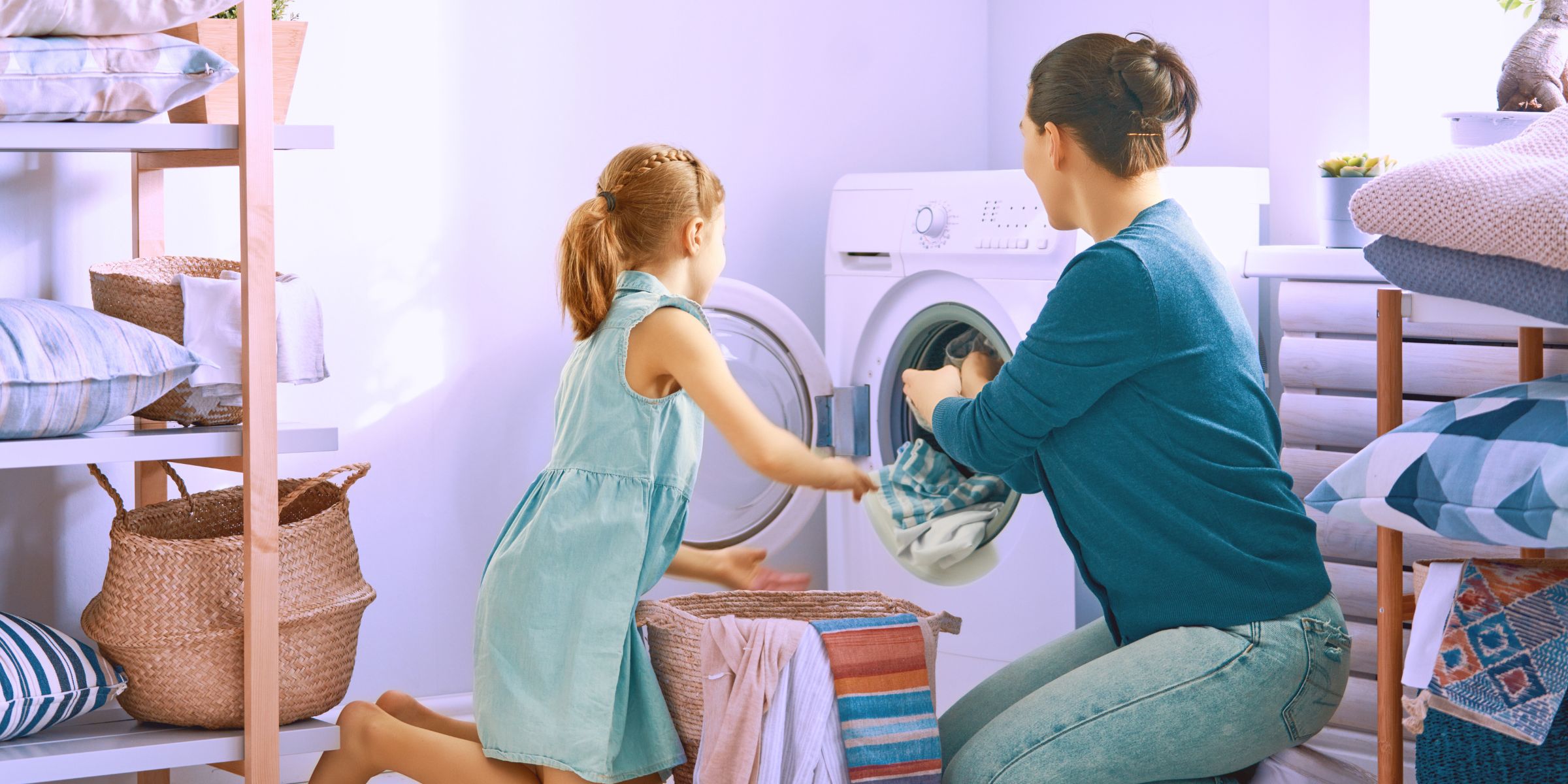 woman strengthening emotional ties with her daughter by teaching her chores like doing laundry