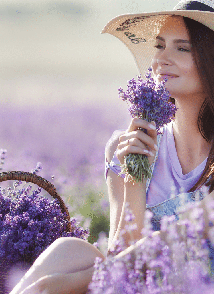 white woman smelling linalool in field of lavender